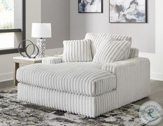 a white chair sitting on top of a rug in a living room