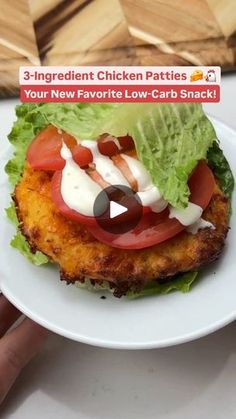 a chicken patty sandwich with lettuce and tomatoes on it is being held by someone