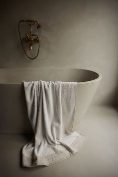 a white bath tub sitting next to a gold faucet