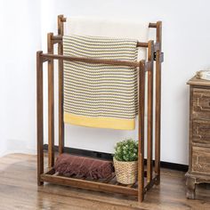 a chair with a towel rack next to it and a potted plant on the floor