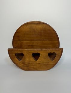 a wooden shelf with three hearts cut out of it's sides on a white background