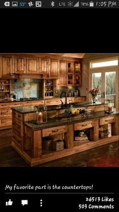 a large kitchen with wooden cabinets and granite counter tops on the island in front of an open window