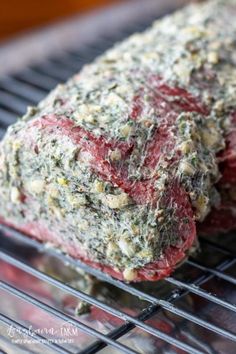 two steaks on a grill with herbs and seasoning sprinkled on them