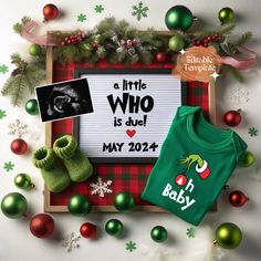 a green shirt and some christmas ornaments on a white background with the words a little who is due may 2012