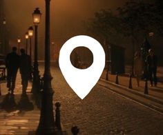 people walking down the street at night with a map pin on it's side