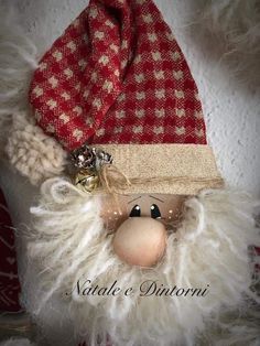 a close up of a stuffed animal wearing a red and white hat with fur on it