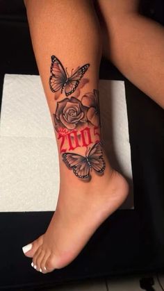 a woman's leg with butterflies and roses on it, the word 2011 written in red