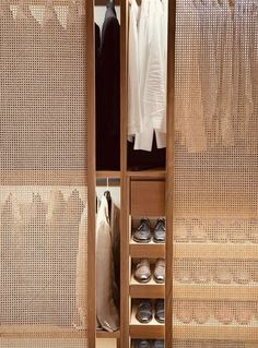 an open wardrobe with shoes and clothes hanging on it