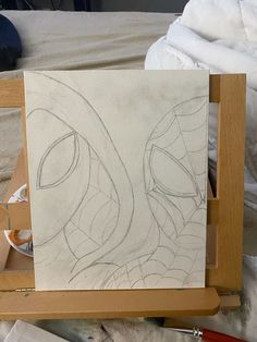 an easel with a drawing on it in the process of being painted by someone