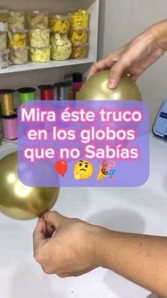 a person is holding some balloons in front of a sign that says, mira est truco en los globos que no sabias