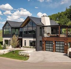 a large modern house with lots of windows on the front and side of it's roof