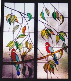 two stained glass windows with birds perched on the tree branch in front of them,