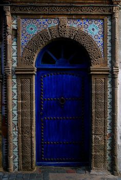 a blue door with ornate carvings on it's sides and an arch above the doorway