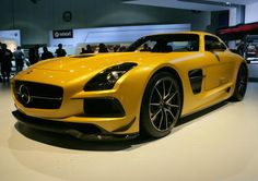 a yellow sports car on display in a showroom