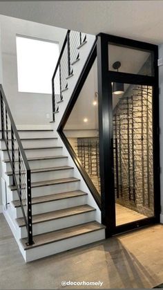 an empty room with stairs leading up to the second floor and wine cellar behind it