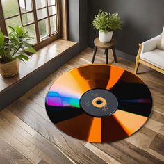 an orange and black disc sitting on top of a wooden floor next to a window