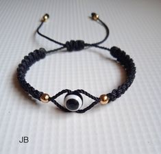 a black string bracelet with an eyeball on it