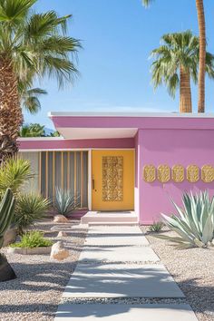 a pink house with yellow doors and palm trees