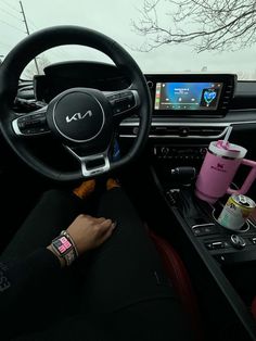 the interior of a car with steering wheel, dashboard and various items on display in it