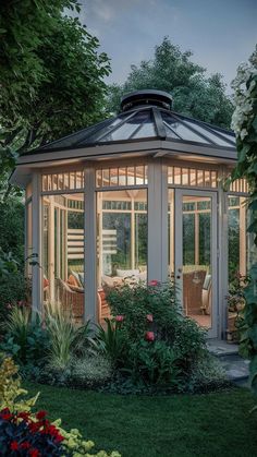 a white gazebo surrounded by greenery and flowers