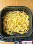 a plastic container filled with pasta on top of a wooden table