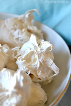 a white bowl filled with whipped cream on top of a table