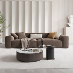 a living room with a couch, coffee table and potted plant in the corner