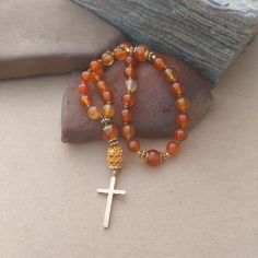 These Anglican Prayer Beads are made with natural Carnelian stone beads. The 10mm Cruciform Beads are framed with gold daisy and spacer beads. The cross is a hammered gold 8mm Amber Spiritual Beads, 8mm Amber Beads For Spiritual Use, Spiritual Hand-strung Amber Beaded Necklaces, Spiritual Amber Round Beads, Spiritual Carnelian 8mm Bead Jewelry, Spiritual Carnelian Round Beads Jewelry, Spiritual Carnelian Beads Jewelry 8mm, Spiritual Carnelian 8mm Beaded Jewelry, Spiritual Carnelian Gemstone Beaded Bracelets