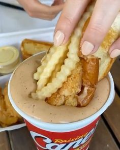 a person is dipping some food into a cup