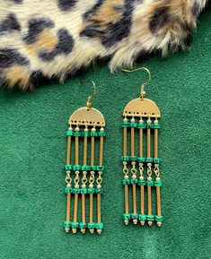 "These dramatic, fully beaded, green and gold statement earrings were designed in the art deco style of the 1920's. These are the perfect earrings for dressing up your holiday attire.  These chandelier statement earrings hang approximately 3.50\" from the lobe and measure approximately 0.75\" inches at their widest point. The design contains 3mm malachite beads and gold plated beads and components. The earwire closure is 18k gold plated and should be suitable for sensitive ears. These are very l Handmade Green Chandelier Earrings For Celebration, Green Beaded Drop Earrings, Handmade Green Chandelier Earrings For Party, Bohemian Green Chandelier Earrings For Party, Bohemian Green Chandelier Earrings For Festive Occasions, Green Beaded Earrings For Festive Occasions, Green Chandelier Drop Earrings, Festive Green Dangle Chandelier Earrings, Green Beaded Dangle Earrings For Celebration