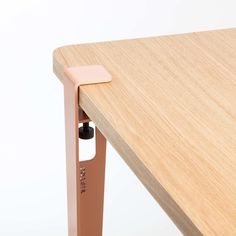 a close up of a wooden table with a pen sticking out of the end section