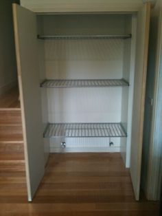 an empty walk in closet with shelves and wooden floors