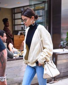 a woman walking down the street carrying a purse