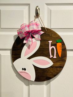 a door hanger with a bunny and carrot on it