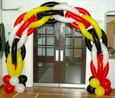 an arch made out of balloons in front of a door