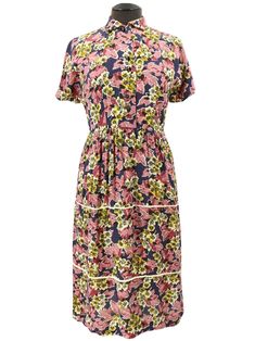 This original forties dress has a beautiful floral pattern, comprising warm pink, yellow and purple shades. The piece is made of a light silk crepe fabric, has short sleeves, and falls below the knee. The dress's bodice features a row of bevelled black buttons and a cute, small rounded collar. The skirt is gathered at the waist and is constructed with tiers which are separated with contrast piping. An eye-catching and feminine original 40s dress. Fastened with the buttons on the bodice and press studs at the side waist. The dress is in good condition, but a repair has been made to the button placket - this is entirely covered when the dress is fastened. Two buttons have been replaced - one is a very similar style, hardly noticeable, while the bottom button is visibly different. There is al Occasion Dresses Uk, 1940s Vintage Dresses, Silk Crepe Fabric, Evening Dresses Uk, Floral Tea Dress, 40s Dress, Silk Dress Vintage, Purple Shades, Bolero Dress