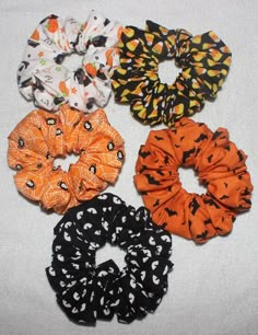 six scrunffles are lined up on a white surface, one is orange and the other is black