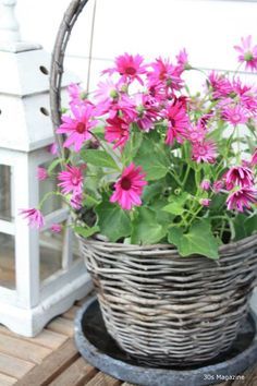 a basket filled with pink flowers sitting on top of a wooden table