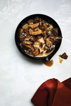 a pan filled with food sitting on top of a white counter next to a red napkin