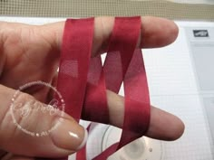 a person is holding a red ribbon in their hand