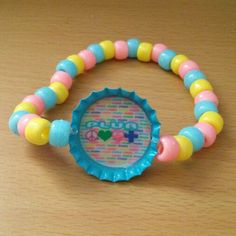 a close up of a plastic bottle cap with beads on it and a name tag