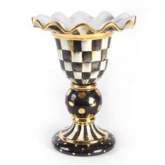 a black and white checkerboard vase with gold trimmings on the bottom