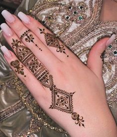 a woman's hand with henna tattoos on it