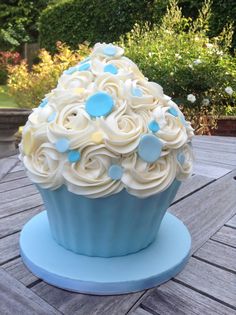 a cupcake with white frosting and blue decorations