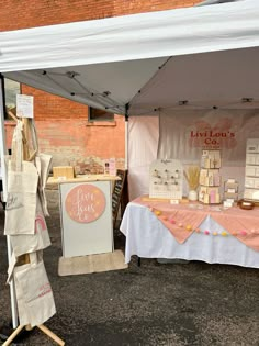 a table with some items on it under a white and pink tented awning