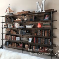 a bookshelf filled with lots of books next to a wall