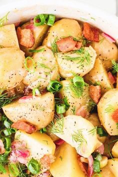 a white bowl filled with potatoes and meat