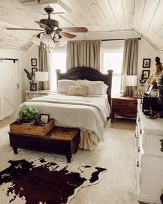 a bedroom with a bed, dresser and ceiling fan