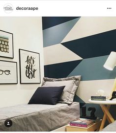 a bed sitting in a bedroom next to a lamp and pictures on the wall above it