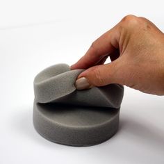 a person is placing something on top of a small round object that looks like it has been made out of concrete